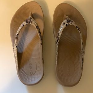 Oofos flip flops with high arch support.